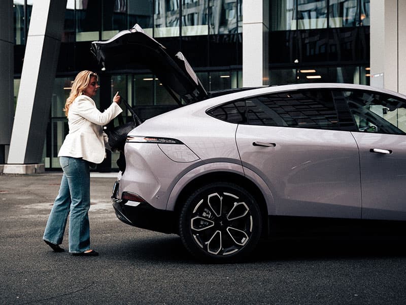 אישה מעמיסה תיק בתא המטען של אקספנג G6