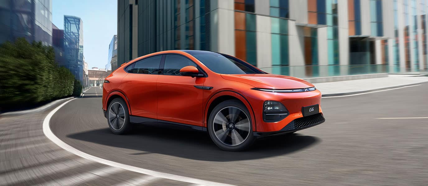 מבט מלפנים על מכונית אקספנג G6 כתומה בנסיעה בעיר