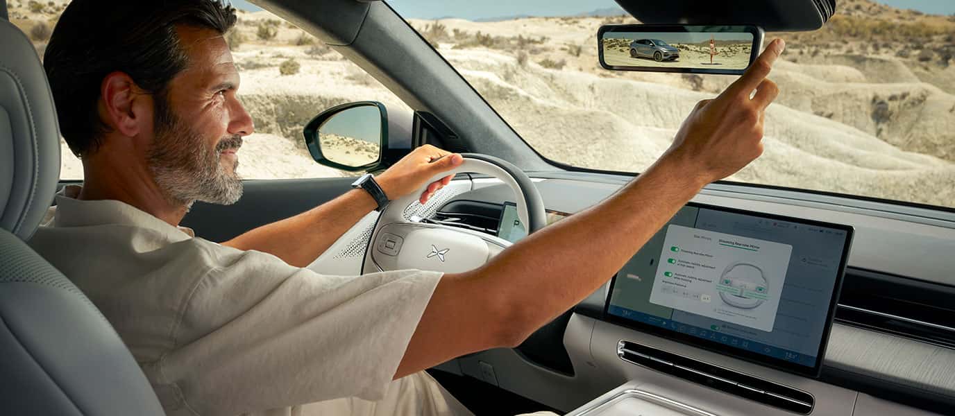 גבר נוהג באקספנג G6 ומכוון את המראה המרכזים החכמה