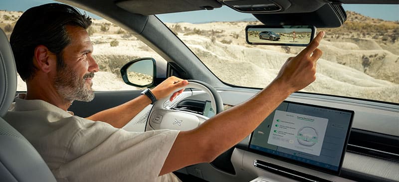 נהג מכוון את המראה המרכזית החכמה ברכב אקספנג