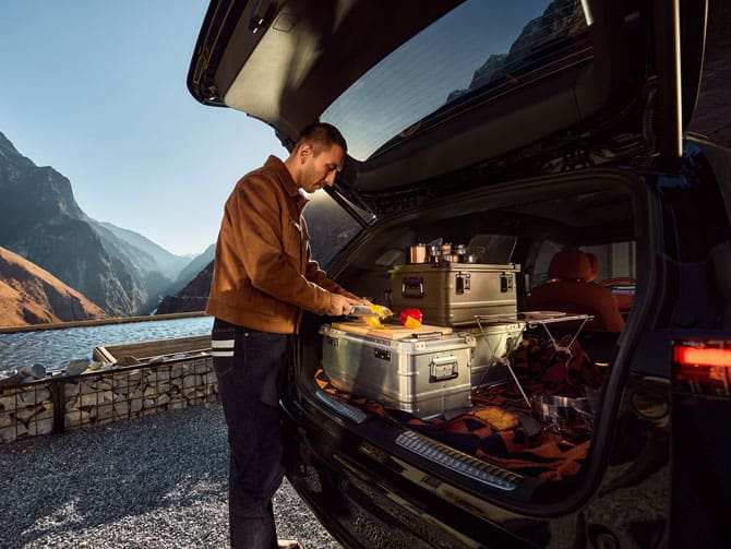 גבר מעמיס חפצים וסחורה בתא המטען של אקספנג G9