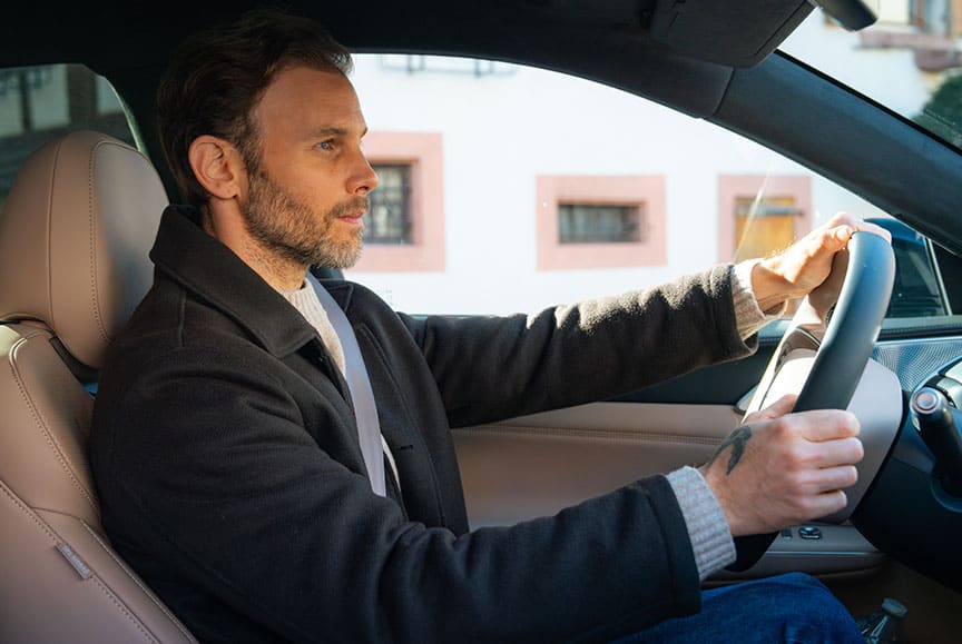 גבר נוהג ברכב חשמלי של אקספנג